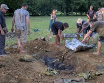 Récupération des poulets. Au fond du trou les pierres chaudes qui ont permis la cuisson