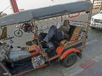 Un chauffeur de tuk tuk fait la sieste en attendant un client
